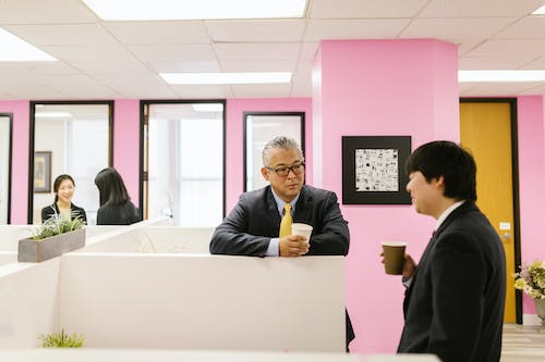 Employees having coffee and talking inside a workplace