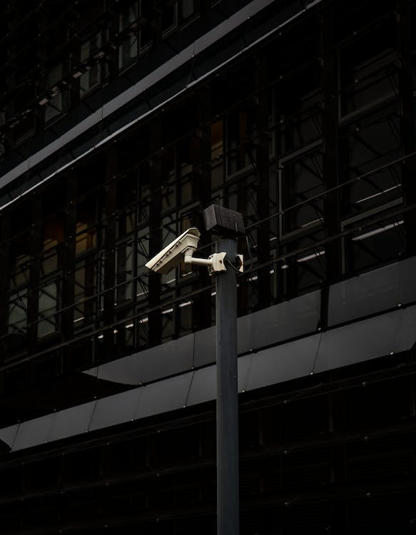 A security camera installed outside of a building on a post