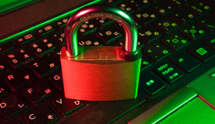 An old-school padlock placed on the keyboard of a laptop.