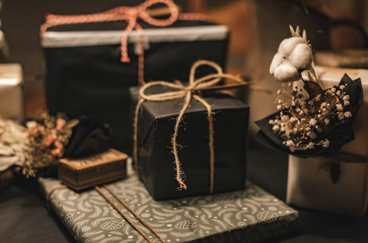 Several gifts are packed and placed on a dark black table